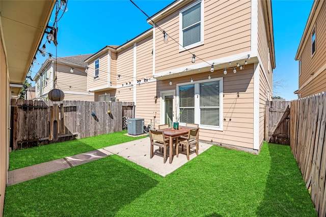 back of house with central air condition unit, a patio, a lawn, and a fenced backyard