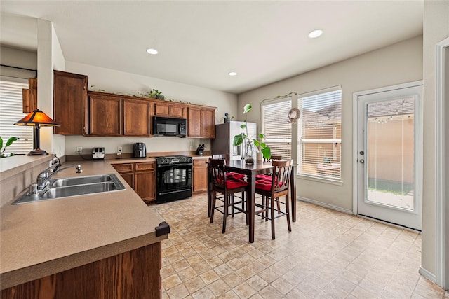 kitchen featuring a sink, black appliances, recessed lighting, and light countertops