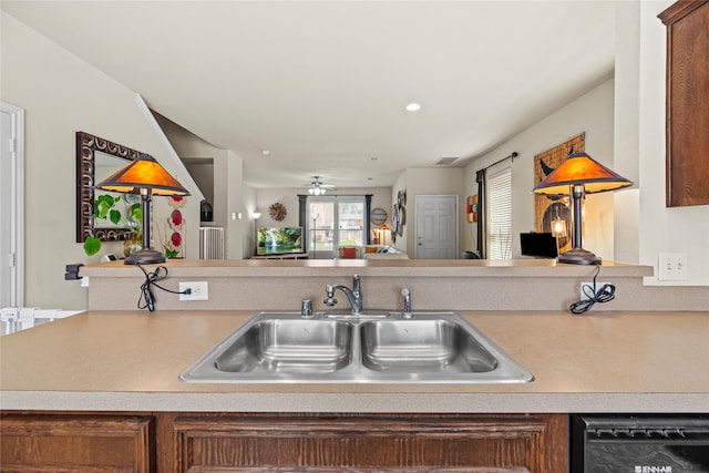 kitchen with visible vents, a sink, open floor plan, light countertops, and dishwashing machine