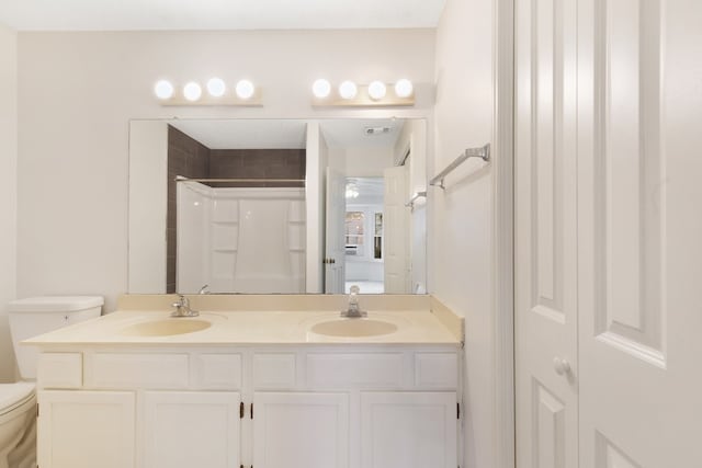 full bath with double vanity, toilet, a shower, and a sink