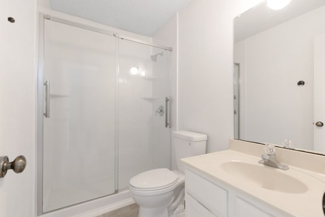 bathroom featuring vanity, toilet, and a shower stall