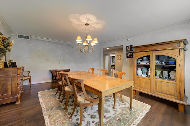 dining space featuring visible vents, a notable chandelier, ornamental molding, and dark wood-style flooring