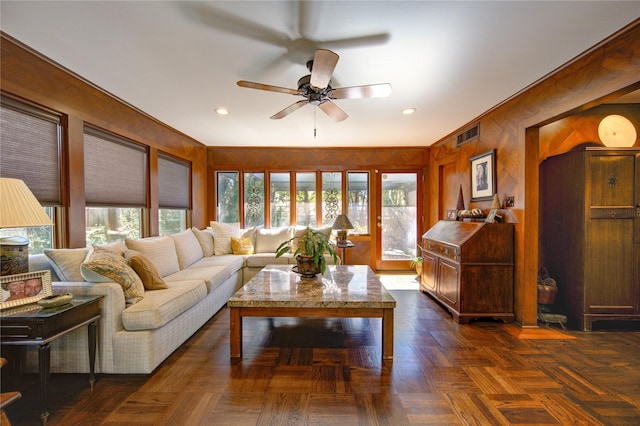 living room featuring recessed lighting, a ceiling fan, visible vents, and wood walls