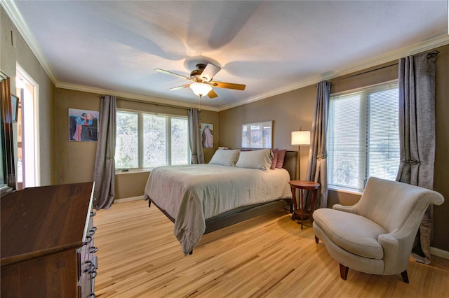 bedroom with multiple windows, crown molding, and light wood-style floors