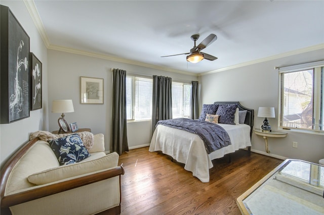 bedroom with baseboards, multiple windows, wood finished floors, and ornamental molding