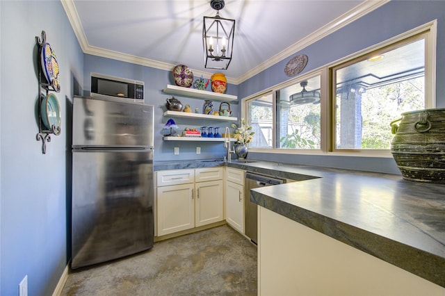 kitchen featuring dark countertops, an inviting chandelier, stainless steel appliances, white cabinets, and crown molding