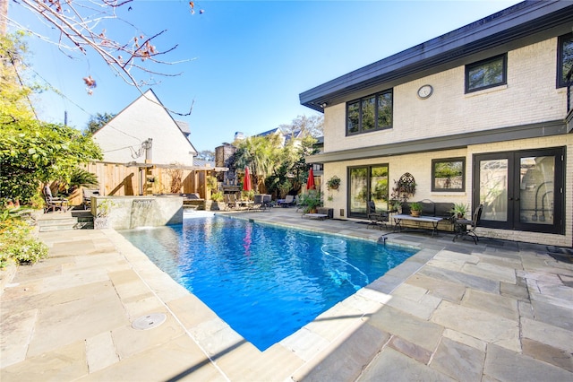 view of swimming pool with a patio area, an outdoor living space, french doors, and fence