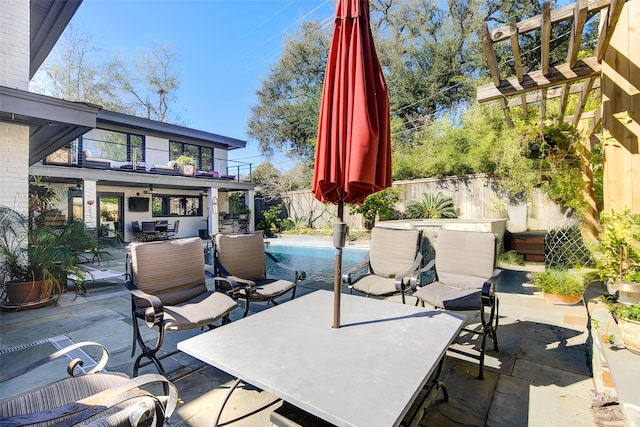 view of patio / terrace featuring outdoor dining space, a balcony, a fenced backyard, and a fenced in pool