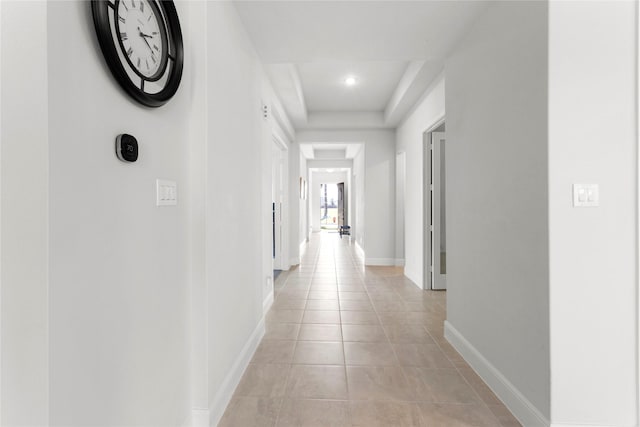 corridor featuring light tile patterned flooring and baseboards