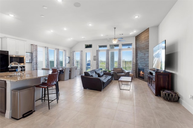 living room featuring light tile patterned floors, recessed lighting, a fireplace, and vaulted ceiling