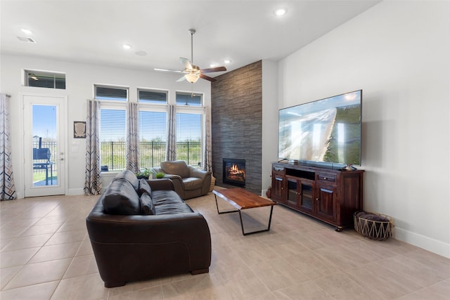 living area featuring light tile patterned floors, baseboards, recessed lighting, ceiling fan, and a large fireplace