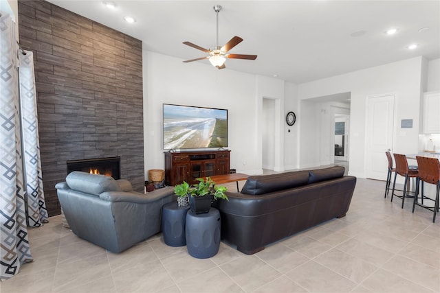 living room with light tile patterned flooring, recessed lighting, a large fireplace, and a ceiling fan