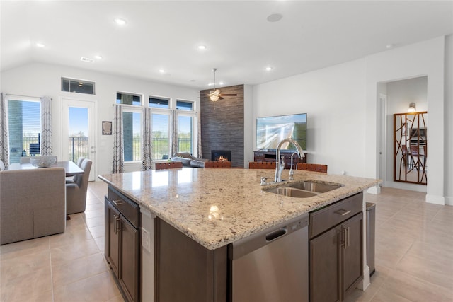 kitchen with recessed lighting, a sink, stainless steel dishwasher, open floor plan, and a large fireplace