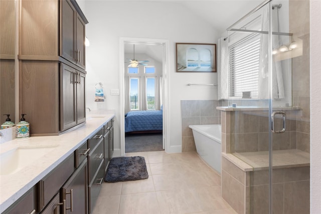 ensuite bathroom with a freestanding tub, a sink, tile patterned flooring, vaulted ceiling, and a shower stall