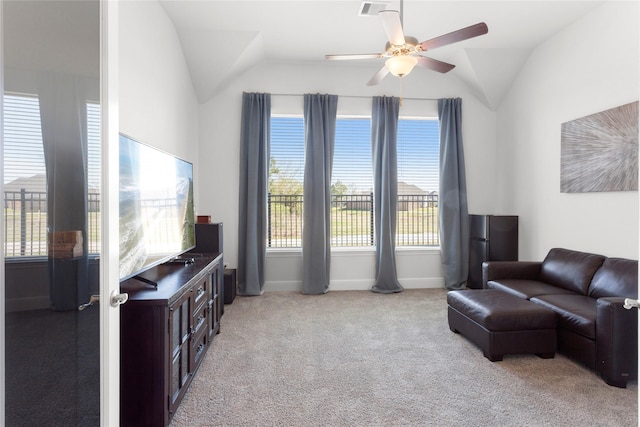 living area with visible vents, light colored carpet, lofted ceiling, and ceiling fan