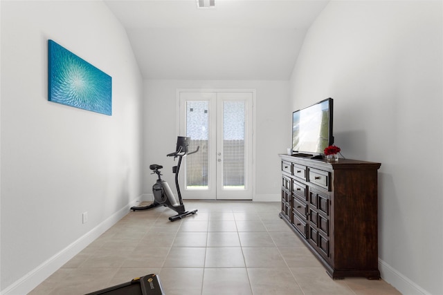 workout area featuring vaulted ceiling, light tile patterned flooring, french doors, and baseboards