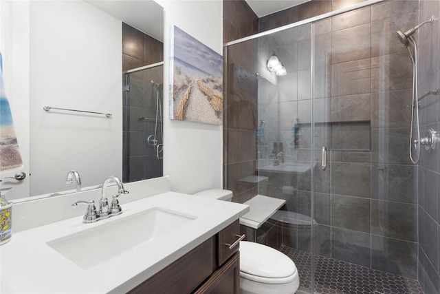 full bath with vanity, a shower stall, and toilet