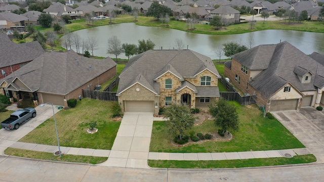 drone / aerial view featuring a residential view and a water view