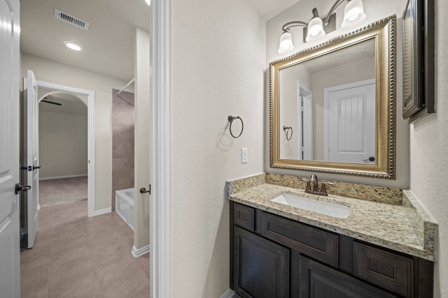 bathroom with tile patterned flooring, visible vents, baseboards, shower / bath combination, and vanity