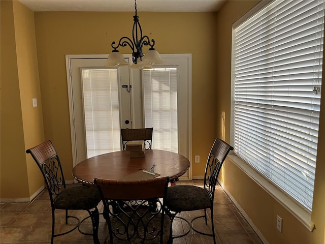 dining space with baseboards and a chandelier