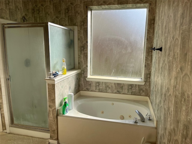 full bath featuring wallpapered walls, a tub with jets, and a stall shower