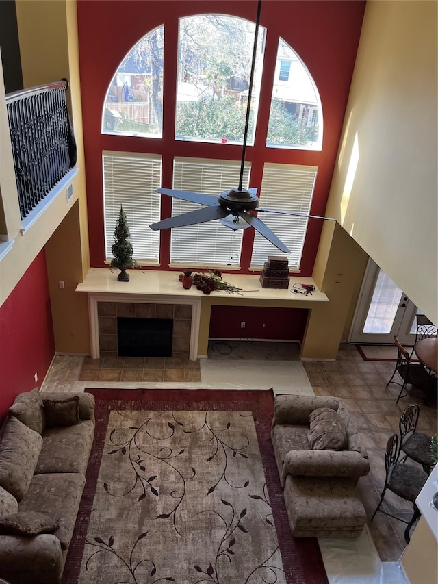 living area with stone finish floor, a ceiling fan, and a towering ceiling