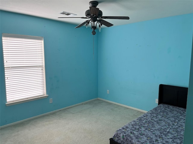 unfurnished bedroom featuring multiple windows, baseboards, visible vents, and carpet floors