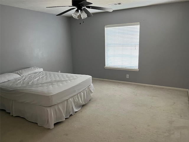 bedroom featuring visible vents, baseboards, light colored carpet, and ceiling fan