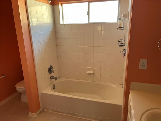 bathroom featuring washtub / shower combination, baseboards, a sink, tile patterned floors, and toilet