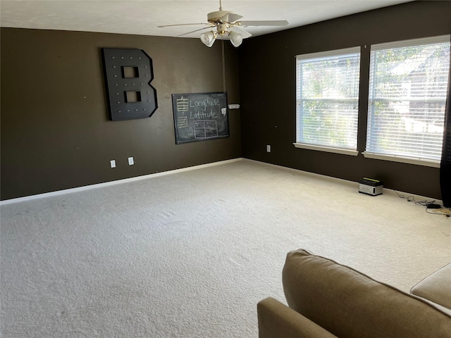 unfurnished room featuring carpet flooring, a ceiling fan, and baseboards