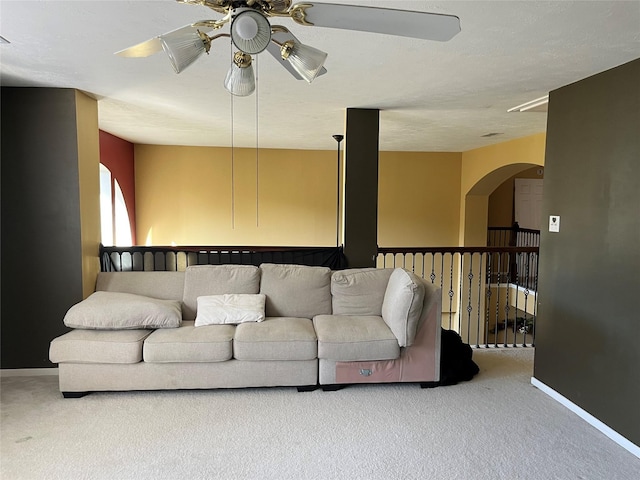 living area featuring baseboards, ceiling fan, and carpet flooring