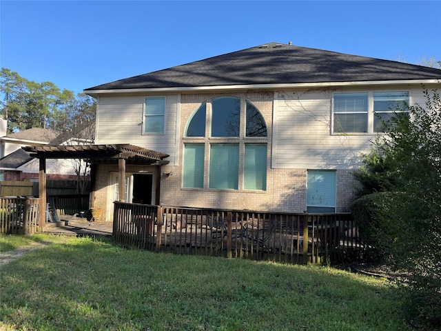 rear view of property with brick siding, a lawn, a pergola, and fence