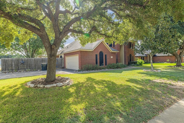 view of front of house featuring brick siding, fence, a front yard, driveway, and an attached garage