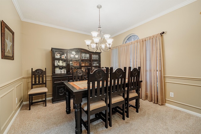 dining space with carpet, a chandelier, wainscoting, and ornamental molding