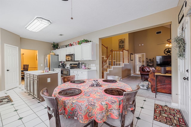 dining area with stairs, vaulted ceiling, visible vents, and ceiling fan