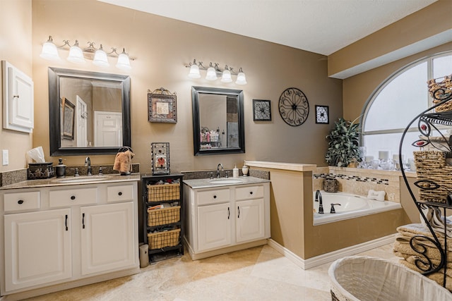 full bath featuring a sink, a garden tub, two vanities, and tile patterned flooring