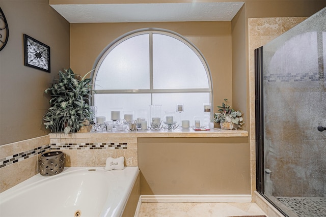 full bathroom featuring a stall shower, a textured ceiling, and a garden tub