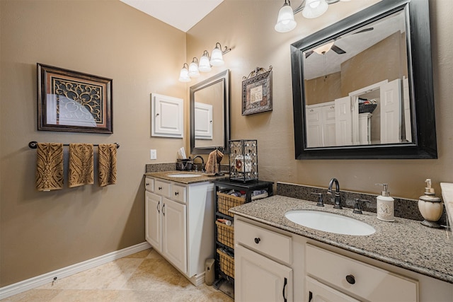 bathroom with a sink, baseboards, two vanities, and tile patterned flooring