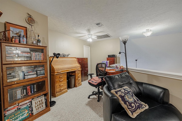 home office with visible vents, a textured ceiling, and carpet flooring