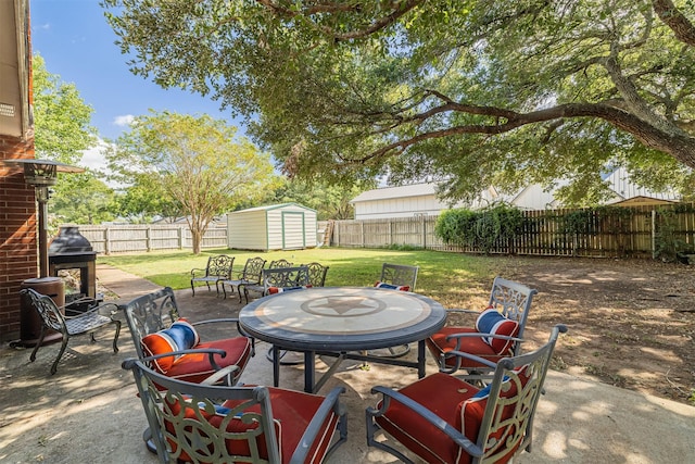 view of patio with a fenced backyard, outdoor dining space, a storage shed, and an outdoor structure