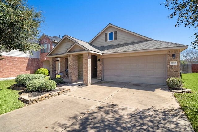 view of front of home with brick siding, concrete driveway, a garage, and fence