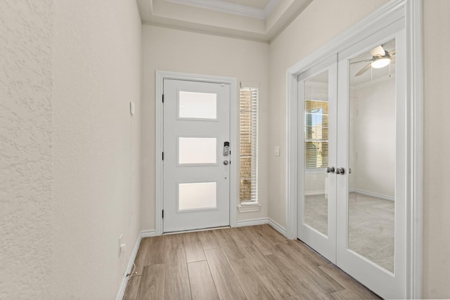 doorway with french doors, baseboards, light wood-style floors, and ornamental molding