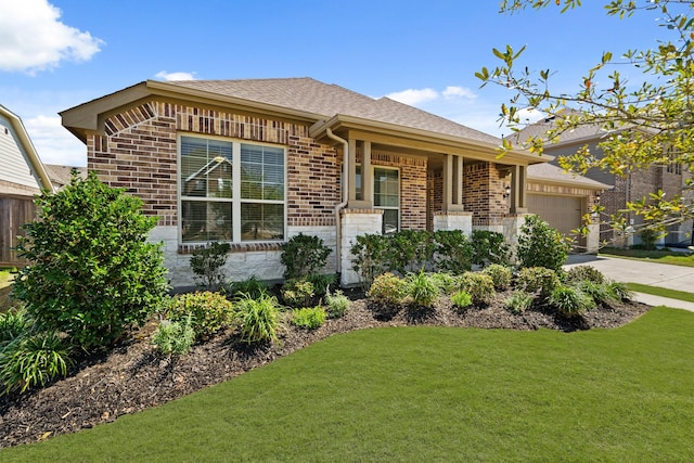 single story home with roof with shingles, concrete driveway, a front yard, a garage, and brick siding