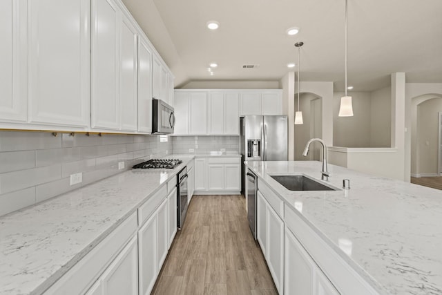 kitchen with a sink, stainless steel appliances, visible vents, and white cabinetry