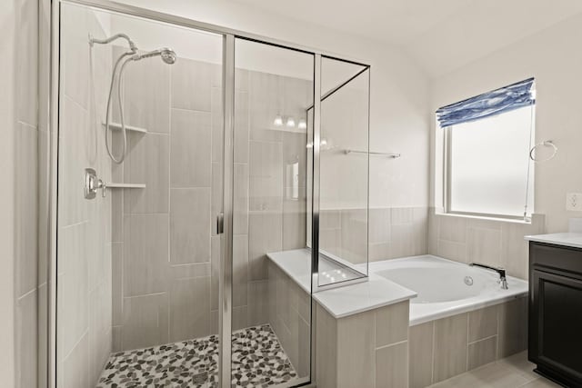 bathroom featuring a garden tub, lofted ceiling, vanity, and a shower stall