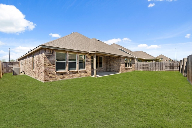 rear view of property with a yard, a fenced backyard, and brick siding