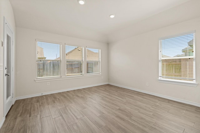 spare room featuring light wood-style flooring, recessed lighting, and baseboards