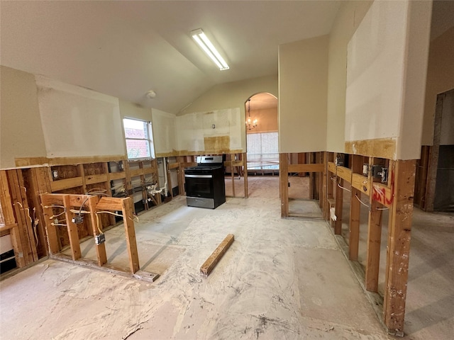 kitchen featuring lofted ceiling, arched walkways, wainscoting, and stainless steel gas range oven