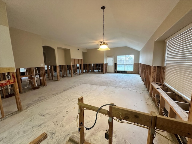 misc room featuring lofted ceiling and arched walkways