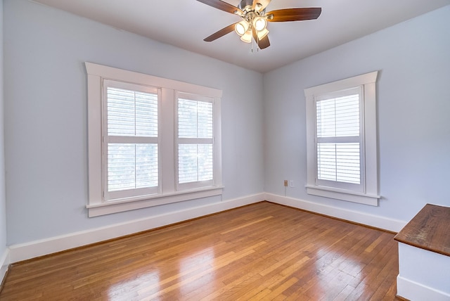 unfurnished room with baseboards, a ceiling fan, and hardwood / wood-style flooring